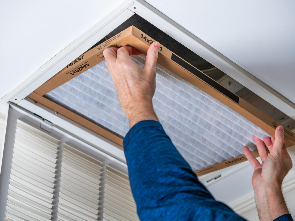 HVAC technician replacing a home air filter in Thousand Oaks