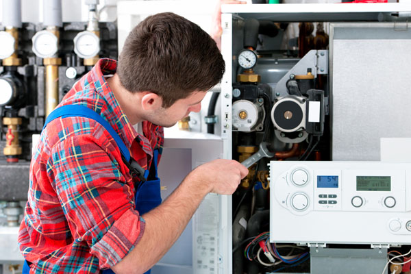 Heating technician repairing boiler controls in Thousand Oaks