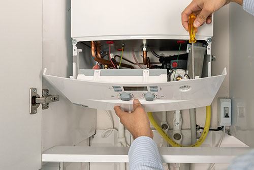 Heating technician repairing a residential boiler in Thousand Oaks