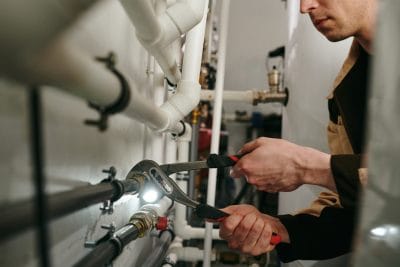 Technician inspecting commercial plumbing pipes in Thousand Oaks