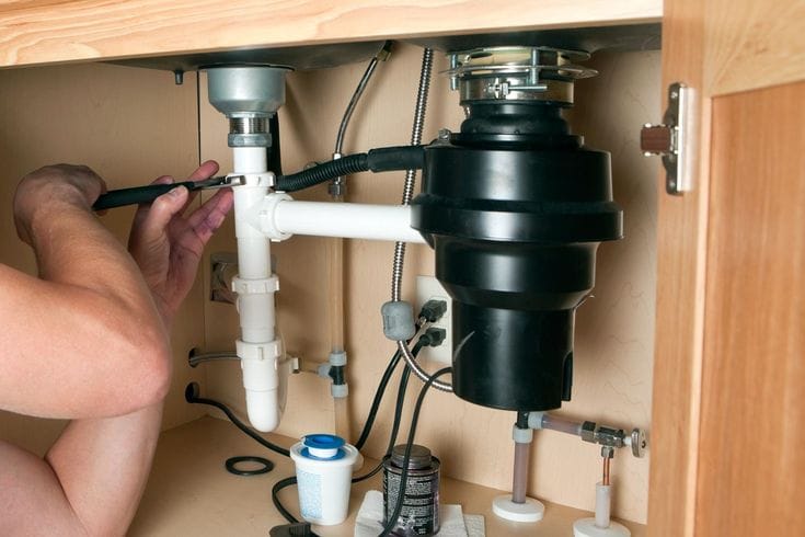 Plumber repairing a garbage disposal in Thousand Oaks