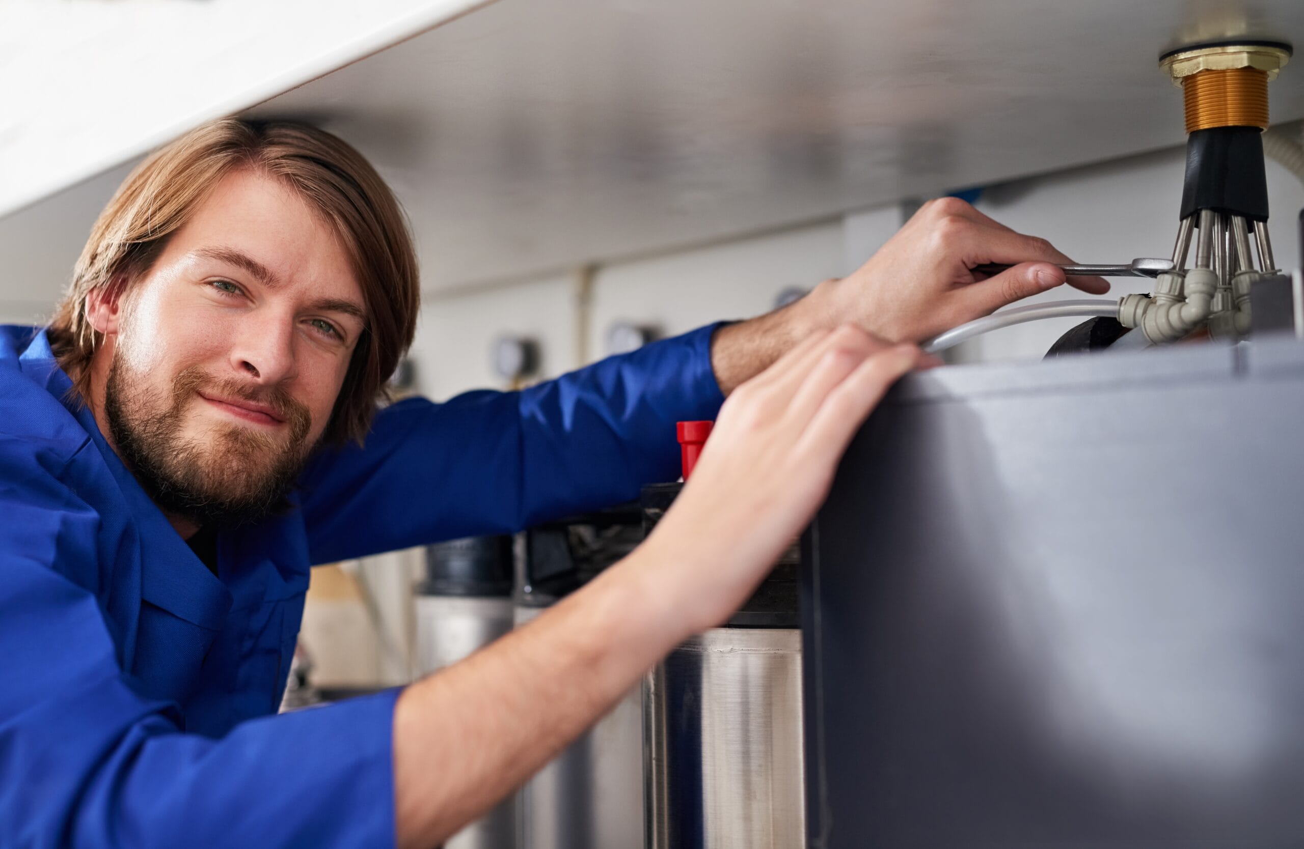 Technician servicing a residential water heater tank in Thousand Oaks